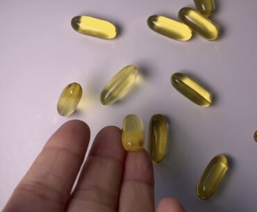 Dropping Gold Fish Oil Capsules Vitamin Supplements FromHand Slow Motion - Free Stock Footage