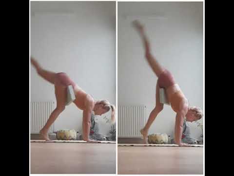 Hand stand with soft yoga block hooked between the upper thigh and the groin